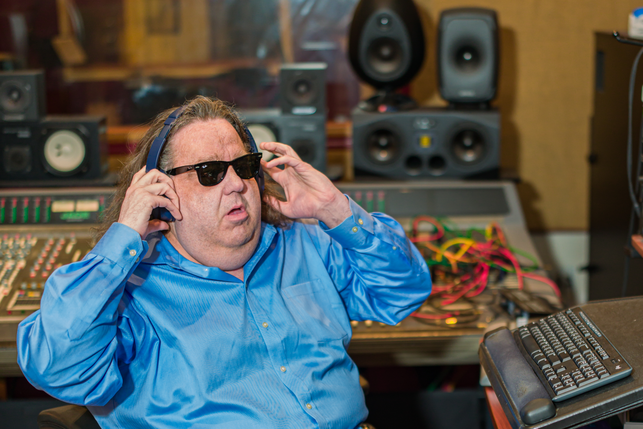 Joey Stuckey wearing headphones at his Shadow Sound Studio workstation while listening critically to a mix.